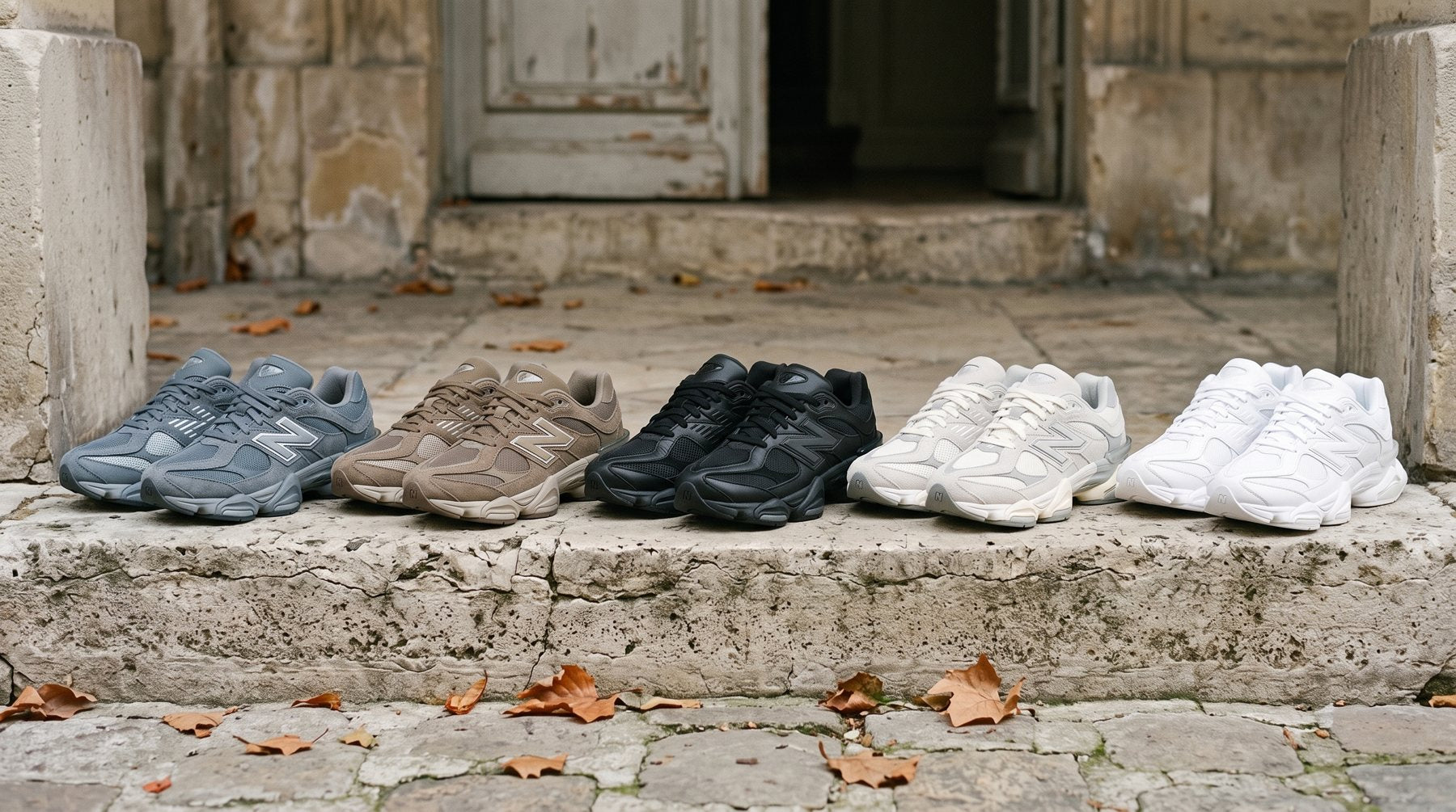 Cinq New Balance 9060 alignées sur une marche en pierre : Vintage Indigo, Mushroom, Triple Black, Grey Moonbeam et Triple White